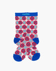 The Step Up Sock by Mother: Tube socks with pink and white smiley faces on a light blue background, featuring bright blue toes, heels, and cuffs. Black stars add a playful touch.