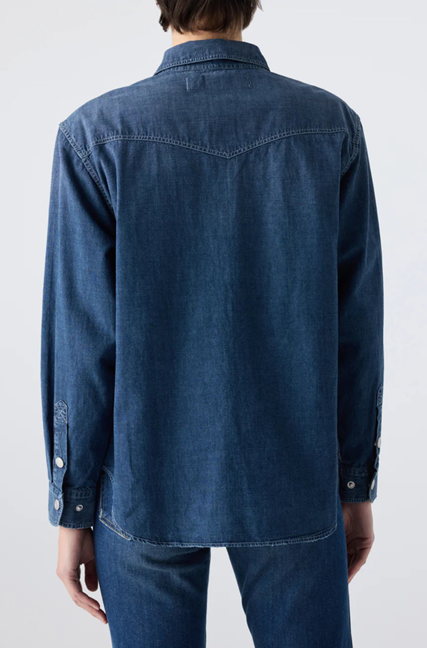 A person is seen from the back, standing against a plain light background, wearing the Angela Shirt by AMO Denim and matching denim jeans.