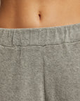 Close-up of a person wearing the Holly Velour Wide Leg Sweatpant by Perfectwhitetee. The focus is on the waistband and part of their lower abdomen, showcasing the luxurious comfort of the plush velour fabric, which has a soft, textured appearance.