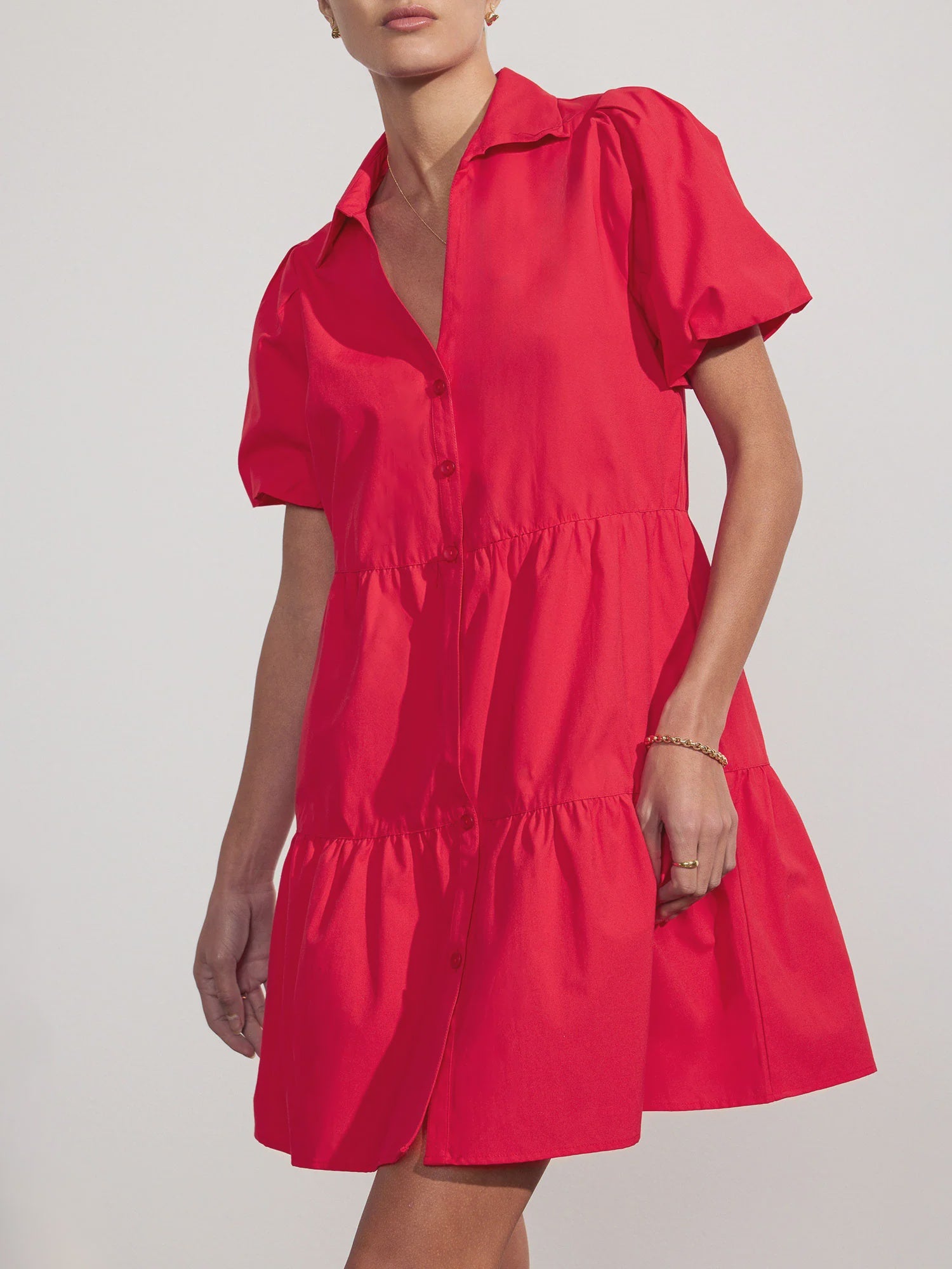 A woman wears the bright red BROCHU WALKER HAVANA MINI DRESS, featuring a collar and subtle puff sleeves, against a plain light background.