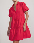 A woman wears the bright red BROCHU WALKER HAVANA MINI DRESS, featuring a collar and subtle puff sleeves, against a plain light background.