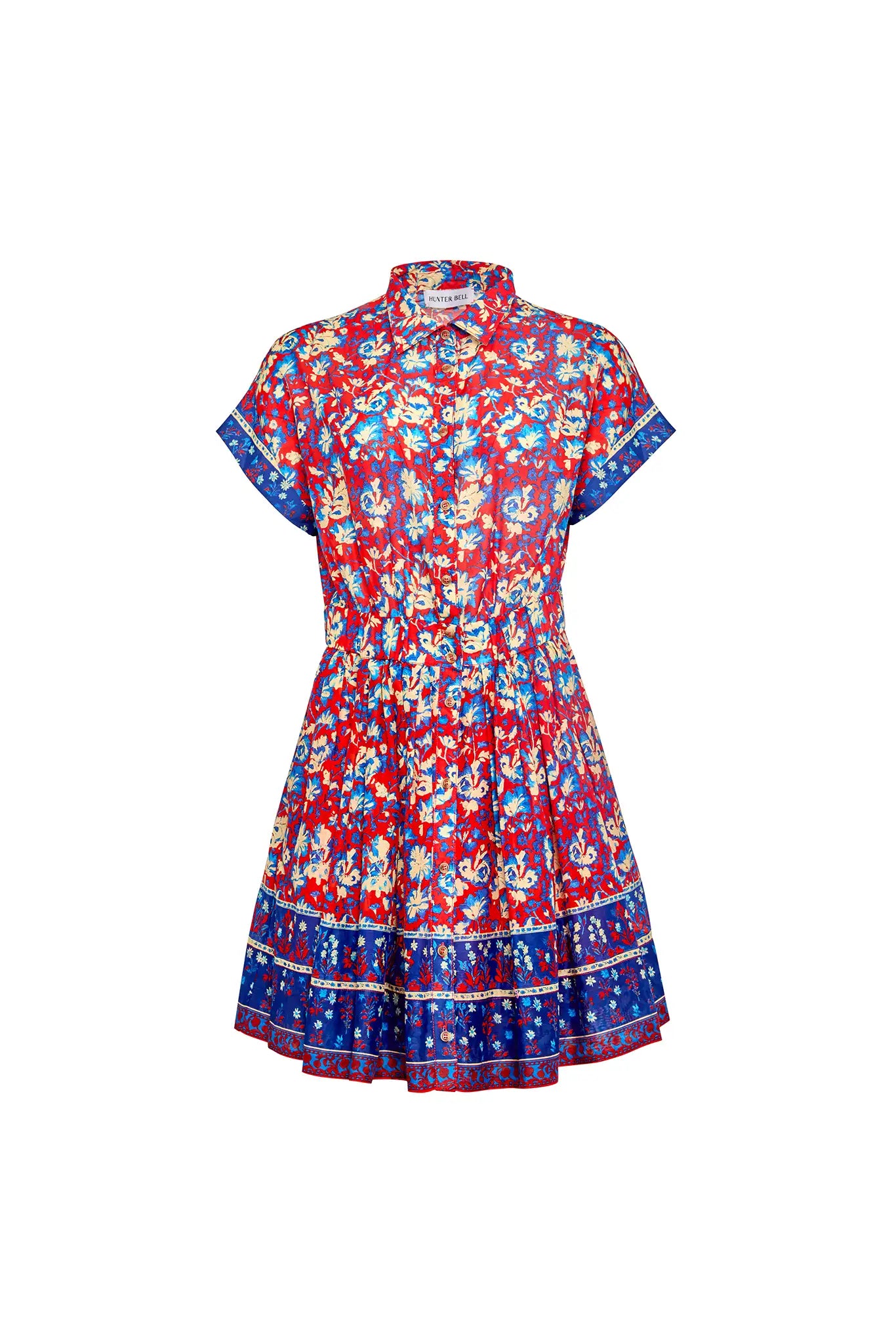 The Howard Dress by Hunter Bell NYC is a short-sleeved, collared button-up featuring a vibrant Tapestry Floral print, flared skirt with blue borders on the hem and sleeves, and an elastic waist for comfort.