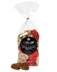 A clear 7.5 oz bag from Abdallah reveals heart-shaped chocolates wrapped in red and gold foil, showcasing their pure milk chocolate delight. The label reads "Milk Chocolate Bags" and "Hugs & Kisses XOXOXO." Three unwrapped chocolates are displayed in front.