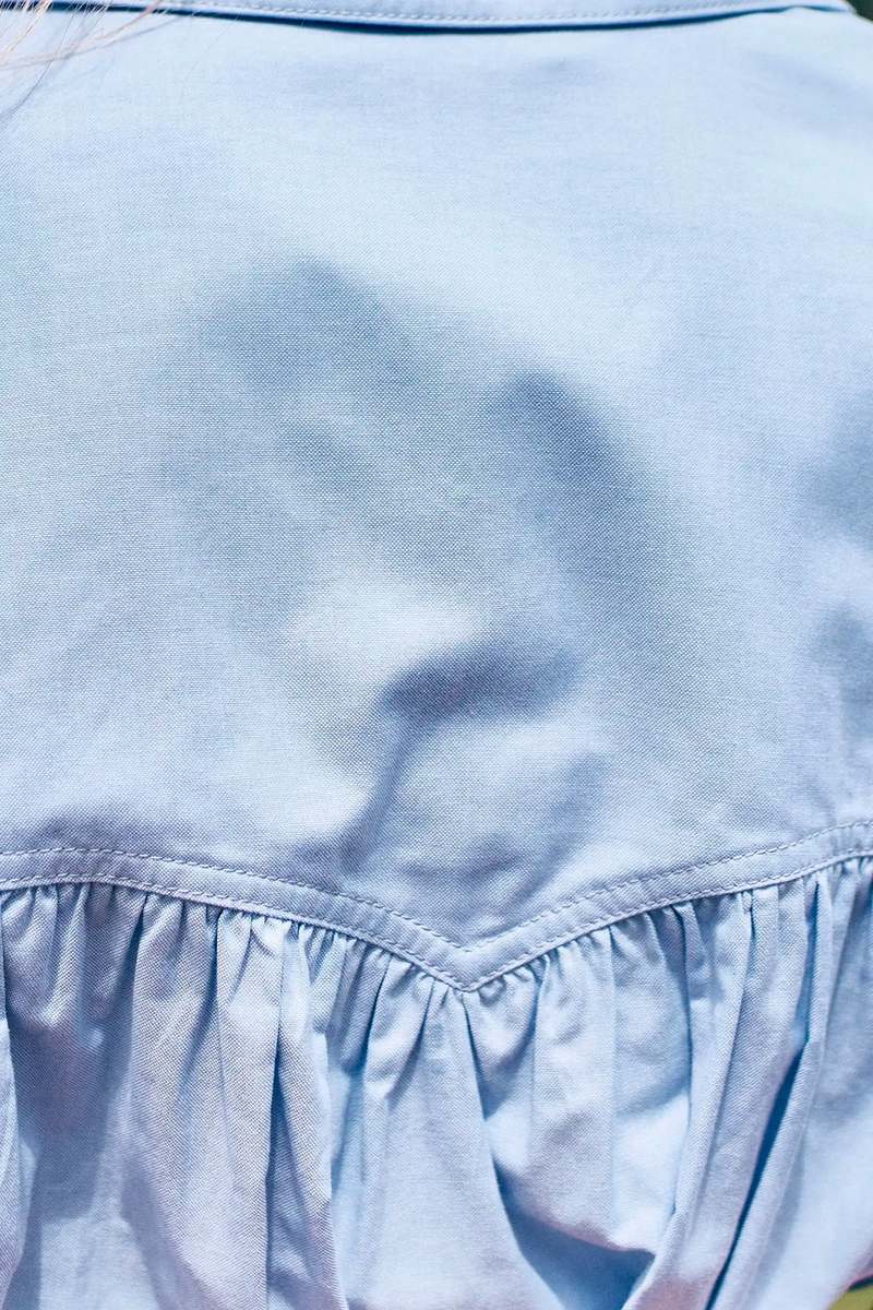 Back of Hunter Bell NYC Evangeline shirt in blue oxford with gathered fabric and detailed stitching.
