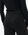 A person is seen from the back wearing Rag & Bone's Irina Cropped Wide Leg Pant with a fitted black long-sleeve top, showing the waist and upper legs against a plain white background.