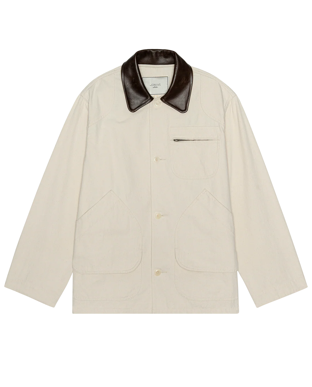 The Great Inc. Barn Jacket in cream cotton canvas features a dark brown leather collar, front buttons, utility pockets—including a zippered chest pocket—and two large front pockets, shown laid flat on a white background.