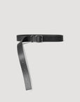 A sleek Janessa Leone Bowe Belt, crafted from regenerative leather, is displayed against a white background. The black belt showcases a metal buckle and an unfastened strap with adjustment holes, embodying the effortless style of Los Angeles.