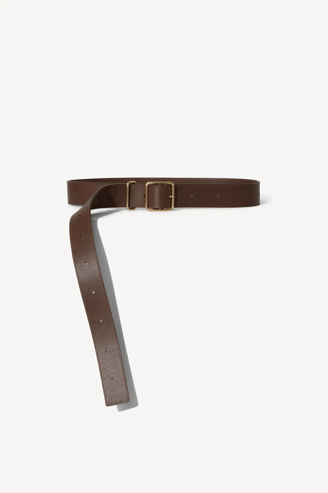 The Bowe Belt by Janessa Leone is crafted from Earth Brown regenerative leather, featuring a custom-designed rectangular brass buckle. It lays against a plain light background with multiple holes for adjustable sizing, and is made locally in Los Angeles.