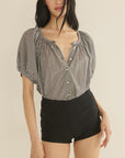 Gingham puff sleeve top by DOEN styled with high-waisted black shorts, casual summer look.