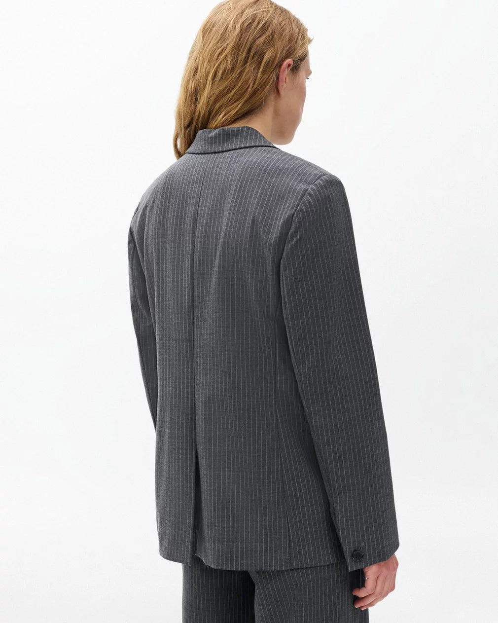 A person with long, light brown hair is shown from behind wearing the Rag & Bone jennifer striped combo blazer against a plain white background.