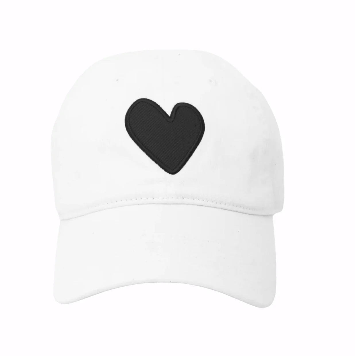 The Embroidered Heart Hat by Kerri Rosenthal is a white cap featuring a bold black embroidered heart on the front, blending classic collegiate style with a modern twist.