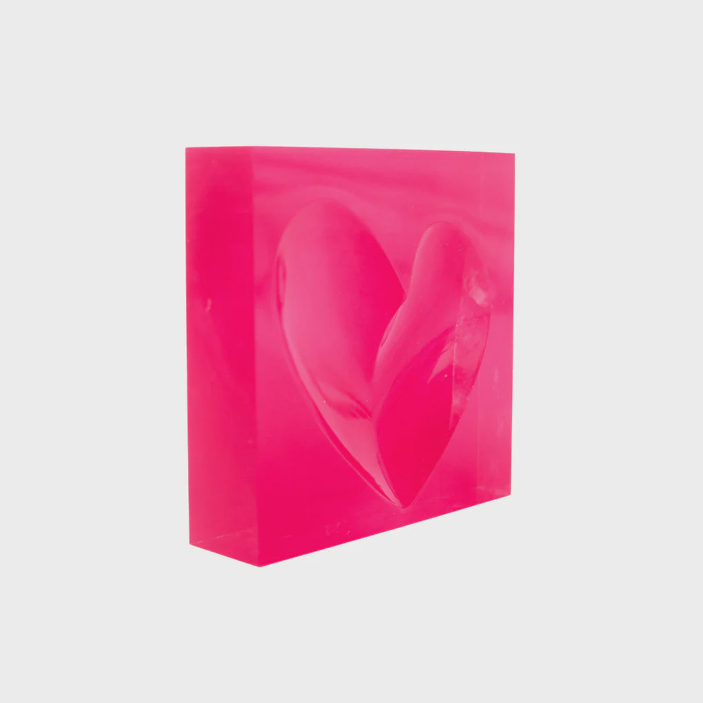 The Mini Heart Decorative Bowl by Kerri Rosenthal is a pink transparent block with a 3D heart shape appearing to float inside, set against a plain white background.