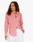 A woman in the Kerri Rosenthal Mia Stripe Shirt—a long-sleeve, red-and-white striped cotton top—paired with white pants stands looking to the side against a plain white background.