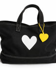 Black cotton tote with white heart detail and yellow leather charm by Kerri Rosenthal, Imperfect Heart Tote.