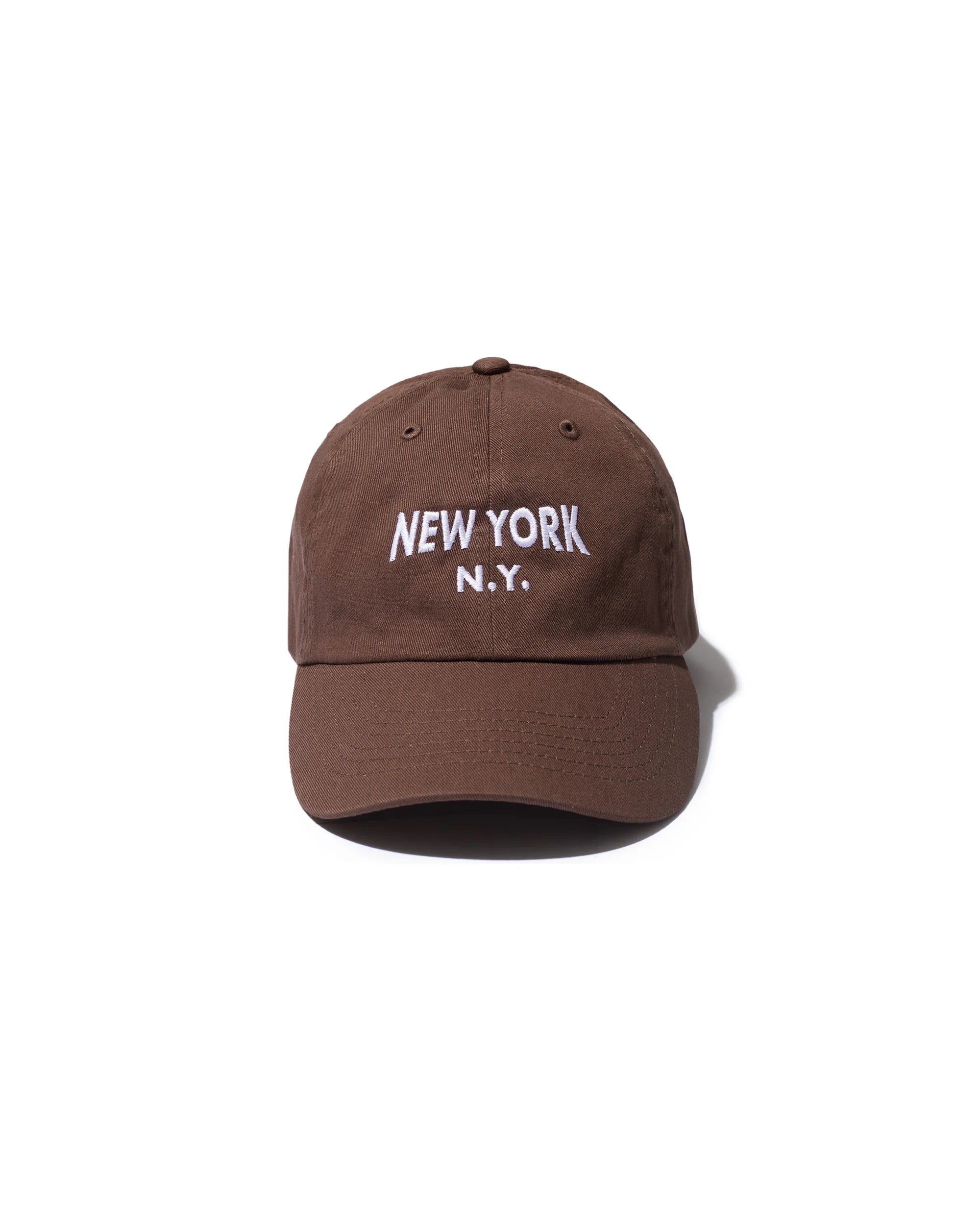A brown Kule New York Kap featuring "NEW YORK N.Y." embroidered in white on the front, shown against a plain white background.