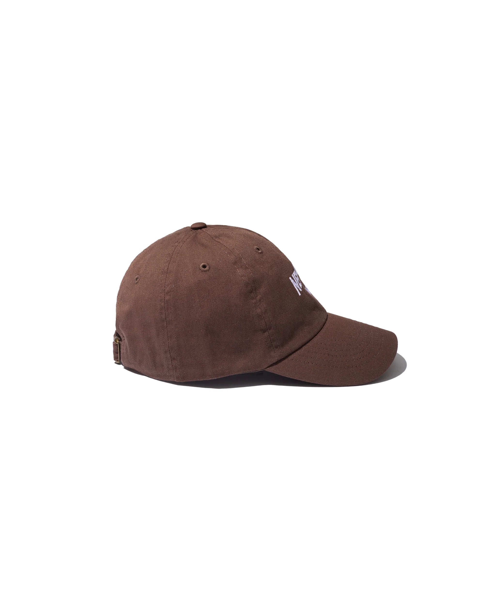 A brown The New York Kap by Kule, featuring a curved brim and adjustable strap at the back, shown in side view against a plain white background.