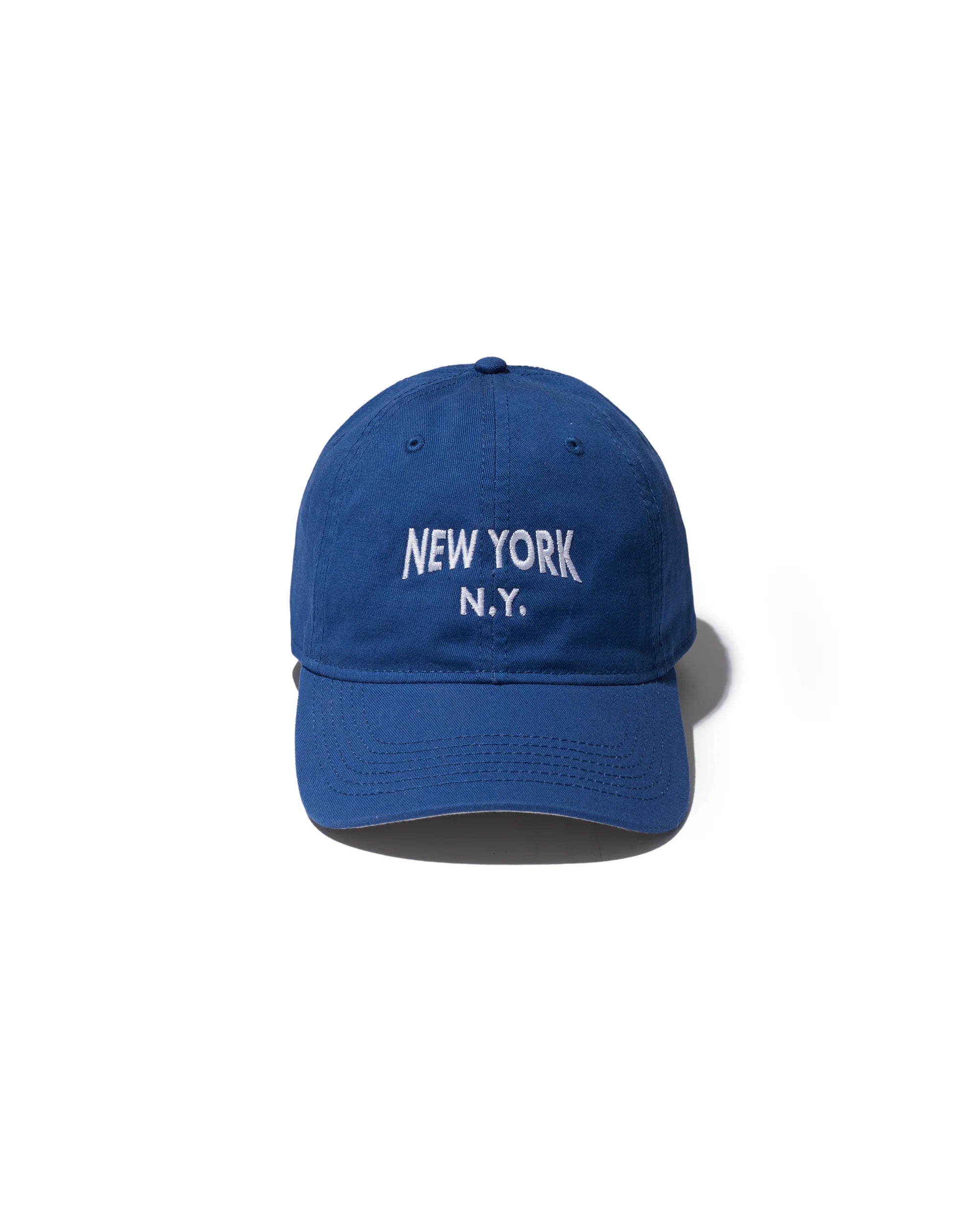 The New York Kap by Kule, a royal blue hat with white "NEW YORK N.Y." embroidery, is shown against a plain white background.