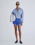 Blue shorts by Love Stories and striped shirt styled with sunglasses and a white bag against a plain background.