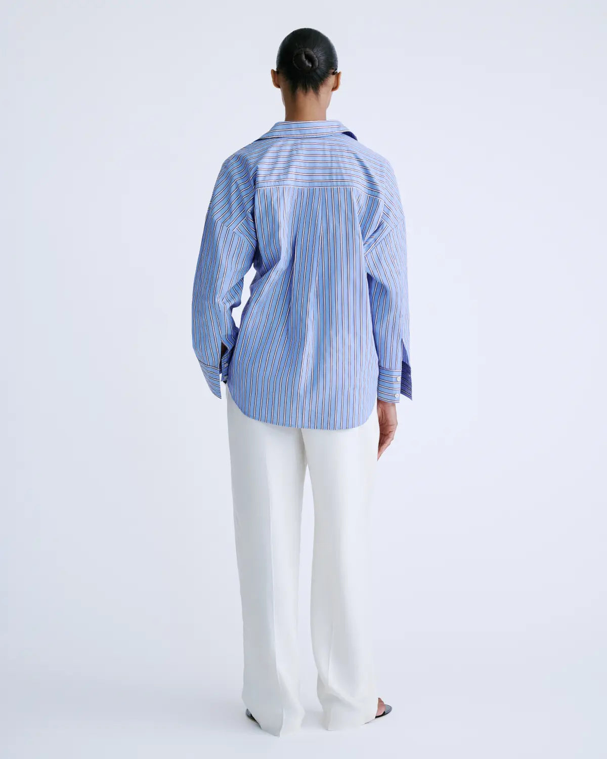 HILLARY striped cotton shirt in white by Love Stories, styled with white pants against a plain backdrop.