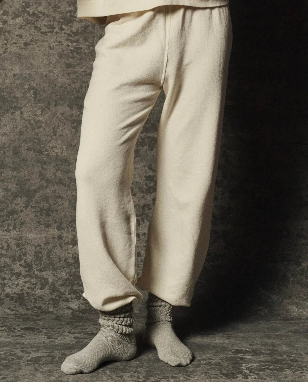 The Great Inc. Dance Pant in gray with matching socks, waist-down view against a textured gray background.