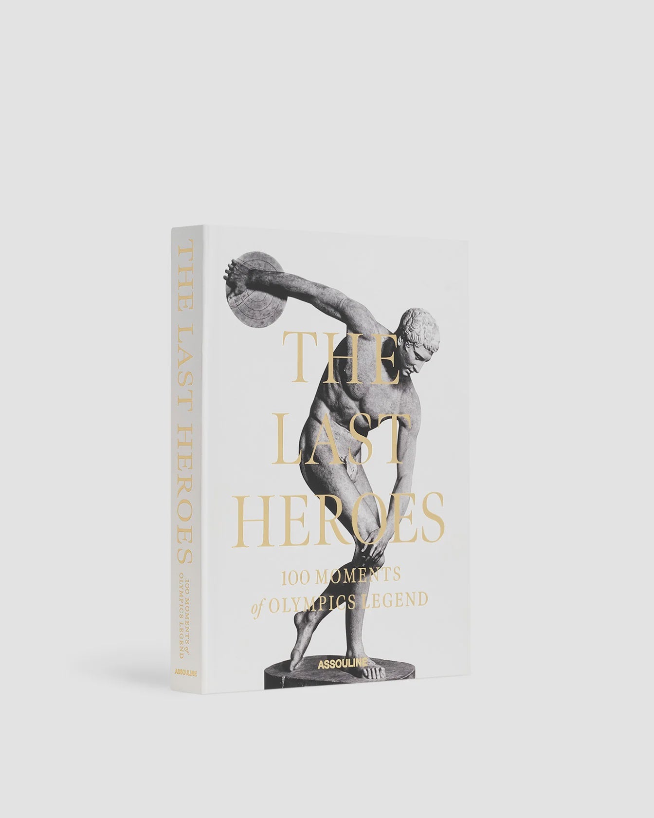 Assouline presents "The Last Heroes: 100 Moments of Olympics Legend," a hardcover book that features a striking black-and-white image of a classical Greek statue of an athlete, possibly a discus thrower, in mid-action on a white background. This essential volume is perfect for fans of Summer Olympics history as we approach the Paris 2024 Olympics.