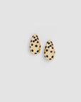 Gold-plated drop earrings with black polka dot enamel by Clare Vivier on a light gray background.