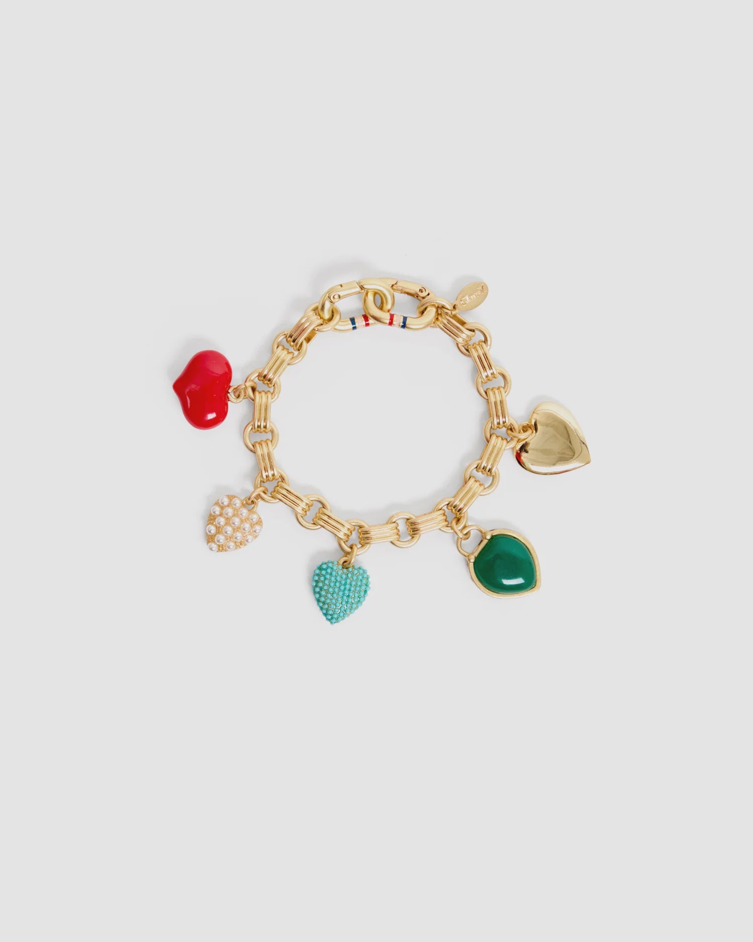 The LE Heartbreaker Bracelet by Clare Vivier features a gold-plated brass chain and five charming pendants—a red apple, gold heart, white pearl cluster, turquoise heart, and green heart—displayed on a plain light background.