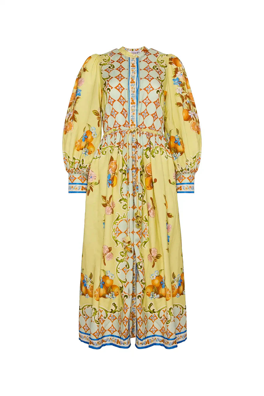 The Lillian Dress by Hunter Bell NYC is an ankle-length, button-front floral dress with long sleeves and a high, round neckline. It has a yellow base with intricate orange, blue, and green floral and geometric patterns, plus a defined waist.