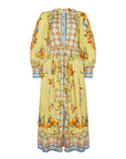 The Lillian Dress by Hunter Bell NYC is an ankle-length, button-front floral dress with long sleeves and a high, round neckline. It has a yellow base with intricate orange, blue, and green floral and geometric patterns, plus a defined waist.