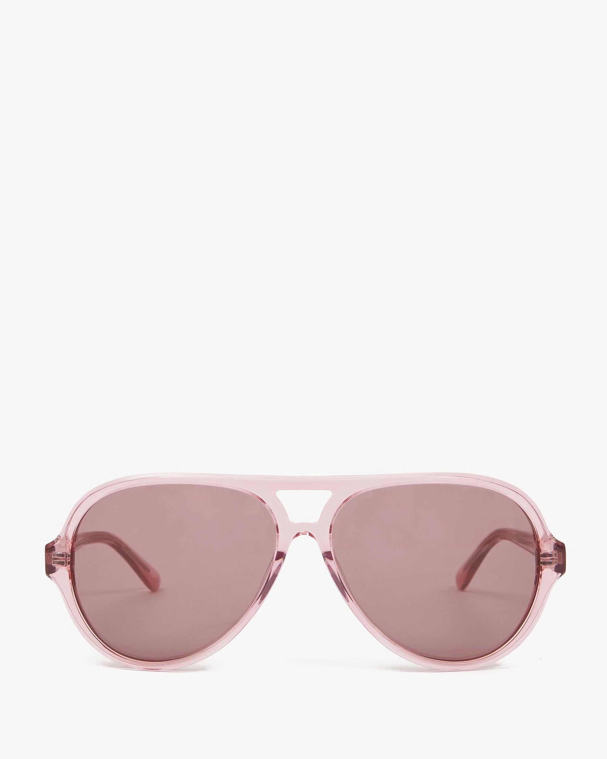 The Lizzie Sunglasses by Clare Vivier are pink aviator shades made from recycled materials, featuring slightly tinted lenses offering UVA/UVB protection. They're showcased front-view against a plain white background.