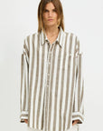 A person with straight, light brown hair models the Denimist BUTTON FRONT SHIRT STRIPE, a relaxed fit long-sleeve shirt with jumbo beige and white stripes, standing against a plain white background.