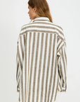 A woman with light brown hair stands with her back to the camera, wearing the Denimist BUTTON FRONT SHIRT STRIPE—a relaxed fit, long-sleeve shirt with jumbo beige and white stripes—against a plain white background.