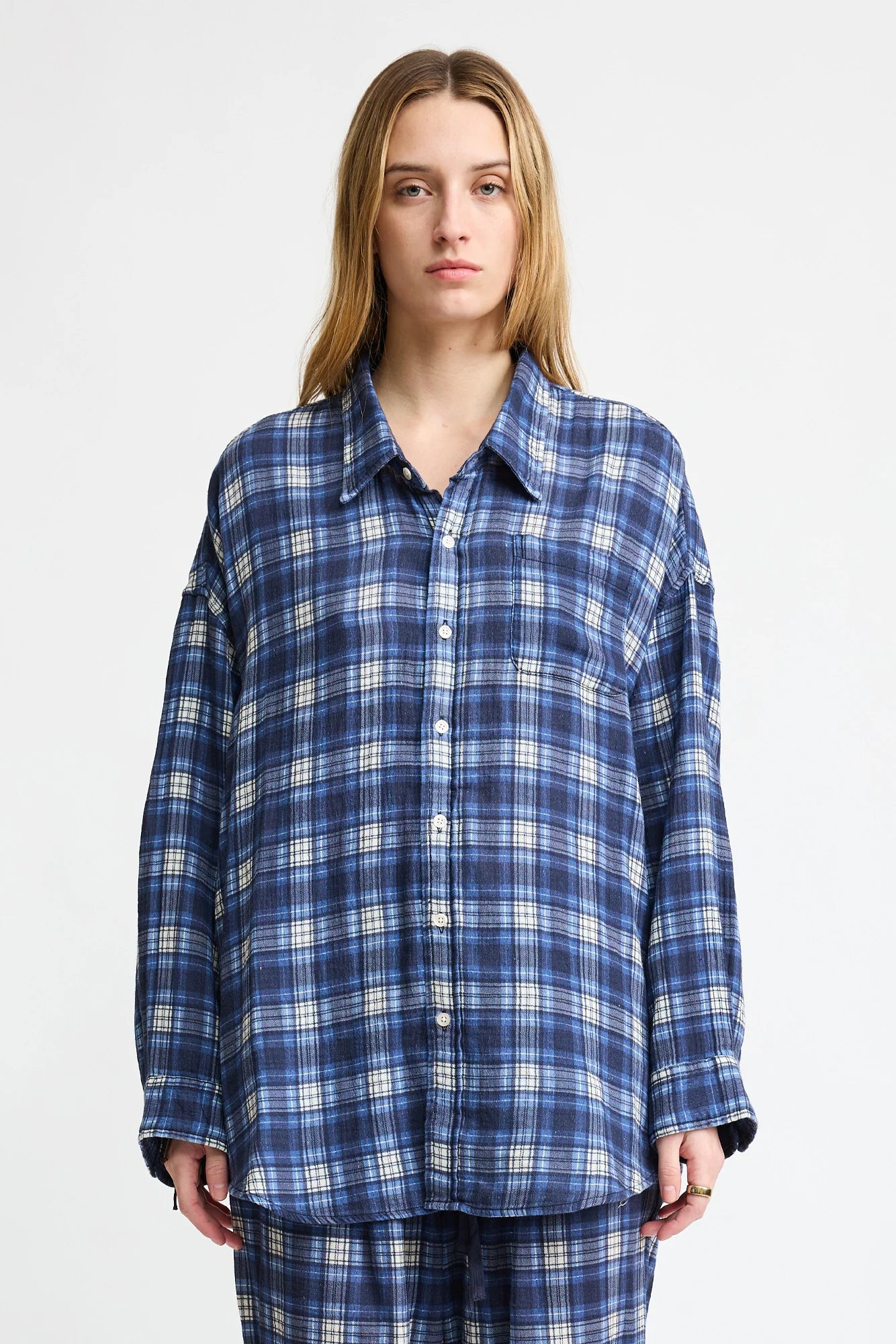 A person with long, light brown hair wears the Denimist BUTTON FRONT SHIRT in blue/ecru plaid, styled with matching plaid pants, standing against a plain white background.