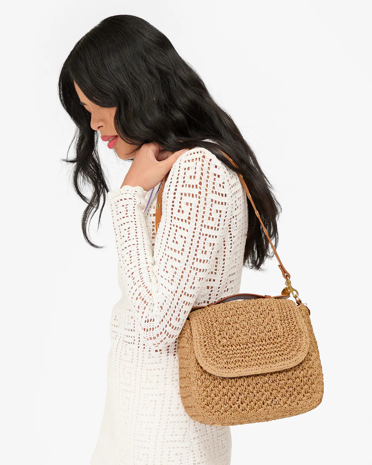 Clare Vivier Turnlock Louis Top Handle tote in white, styled with a long white dress for an elegant look.