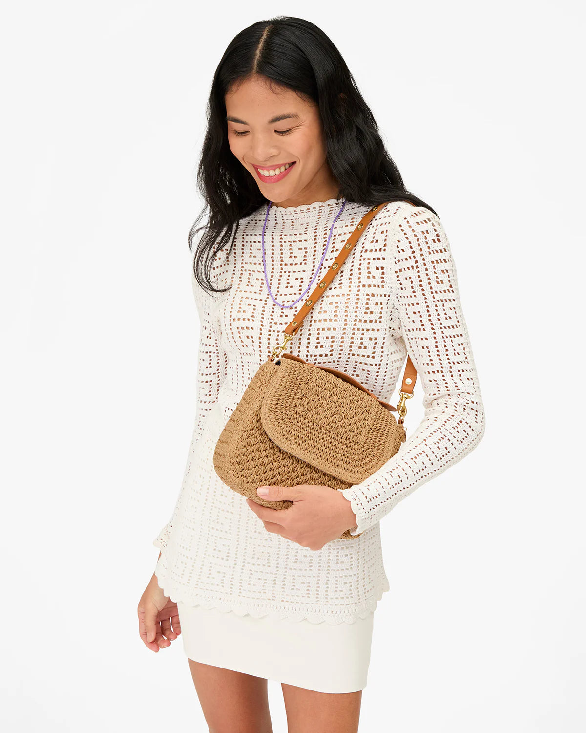 Clare Vivier Turnlock Louis top handle bag styled with a white crochet dress and purple necklace for a fresh, airy look.