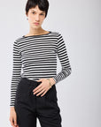 A person with short dark hair wears the Majestic Filatures Organic Cotton Stripe L/S Crewneck and black pants, standing against a plain light background, looking at the camera with a neutral expression.