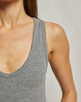 A person models the bestselling Maria Rib V Tank by Perfectwhitetee, a gray ribbed sleeveless top. The focus is on the upper body, emphasizing the fabric texture and design.