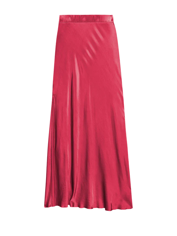 The Maribel Bias Skirt w/ Slit by Nation LTD is a long, flowing silk skirt in vibrant pink with a subtle sheen and a bias cut design. It features an elastic high waist and a slight flare at the bottom, giving it a smooth, seamless appearance that effortlessly enhances its graceful silhouette.