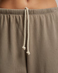 Close-up of a person wearing the buttery soft French Terry Easy Sweatpant in light brown by Perfectwhitetee, featuring a white drawstring. The focus is on the waist area, highlighting the luxurious french terry cotton texture and drawstring detail against a neutral, blurred background.