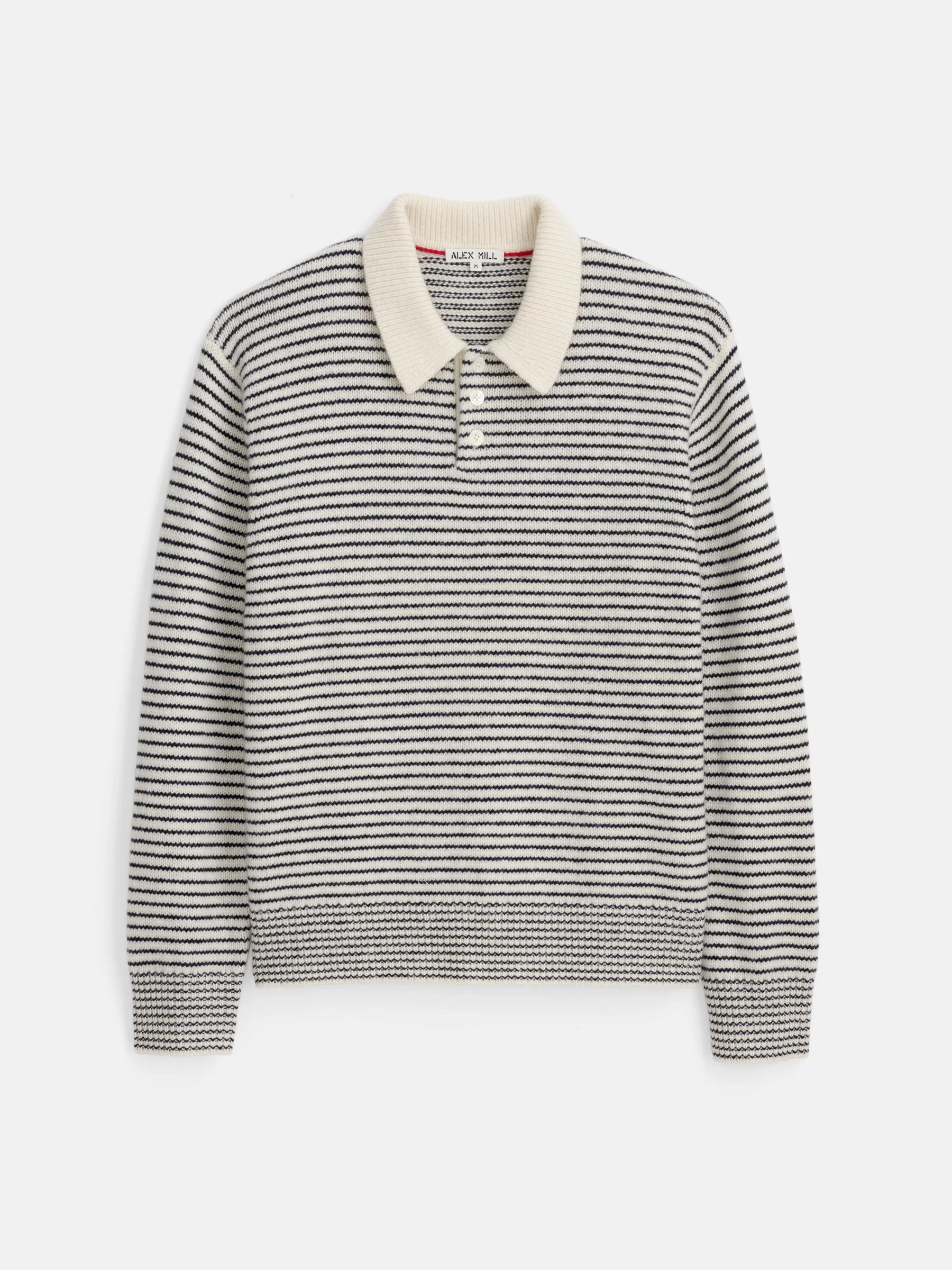 The Highland Collared Sweater by Alex Mill is a long-sleeved, black and white horizontally striped sweater crafted from soft merino wool. It features a cream-colored collar and a shell button placket, adding a touch of contrast to the cozy design. The sweater is showcased against a plain white background.