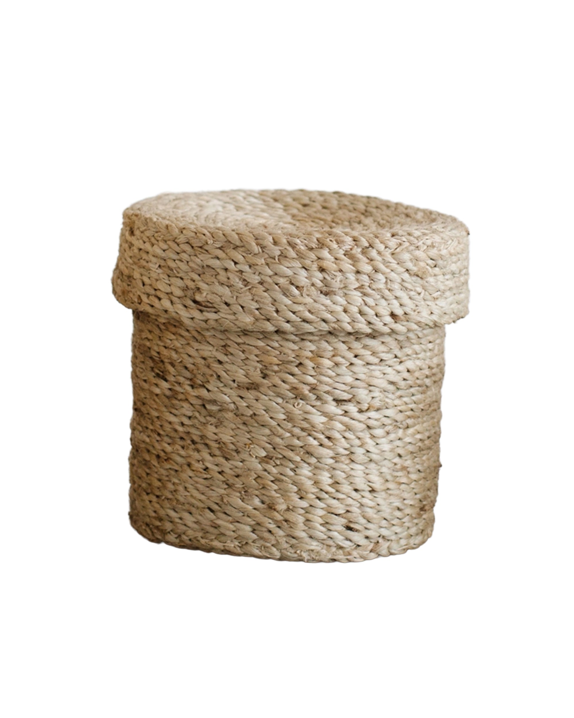 The Faire Round Lidded Jute Basket is a small, round storage basket with a matching lid, crafted from natural jute fibers and shown against a white background.