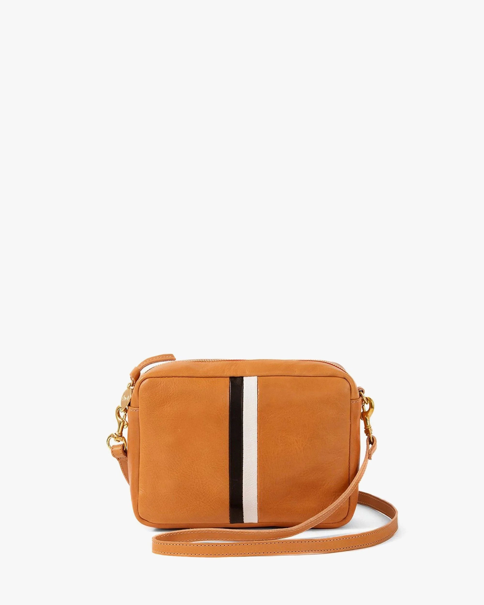 The Clare Vivier Midi Sac S25 is a small, rectangular tan leather crossbody bag with a long strap, front pocket, vertical black and white center stripe, chambray-lined interior, and gold-tone hardware.