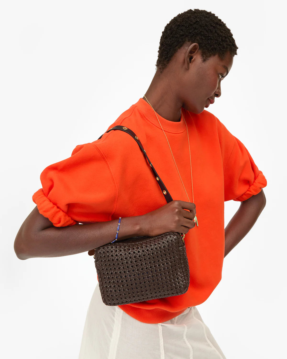 Clare Vivier orange oversized short sleeve sweatshirt with dark brown cotton fleece shoulder bag.