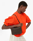 Clare Vivier orange oversized short sleeve sweatshirt with dark brown cotton fleece shoulder bag.