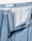 Close-up of light blue Rag & Bone miramar slink lounge pant with undone waistband, zipper, and metal button, revealing white interior lining and visible brand label inside waistband.