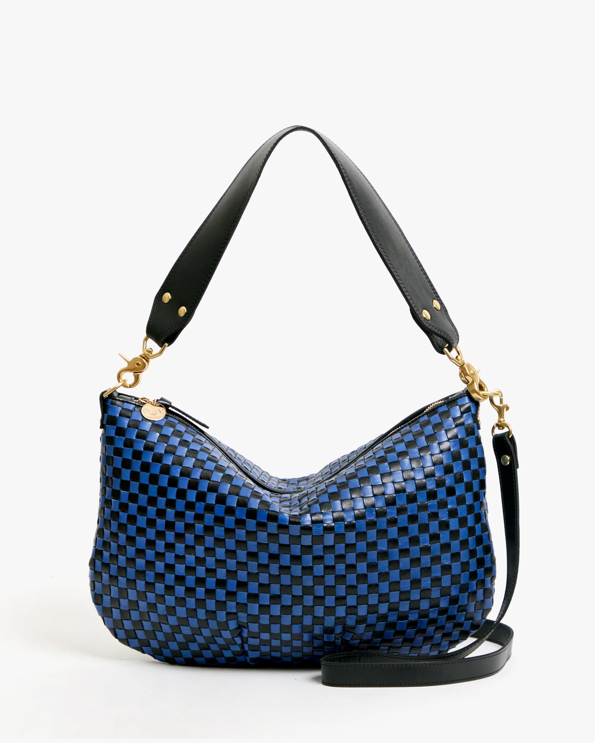The Clare Vivier Moyen Messenger S25 is a blue and black checkered handwoven leather bag featuring black leather shoulder straps and gold hardware, showcased against a plain white background.