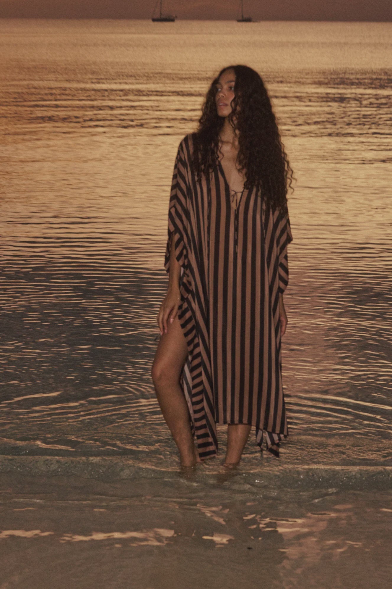 Natalie Martin Paulina Caftan in sunset light, styled oceanside with sailboats for a breezy, relaxed look.