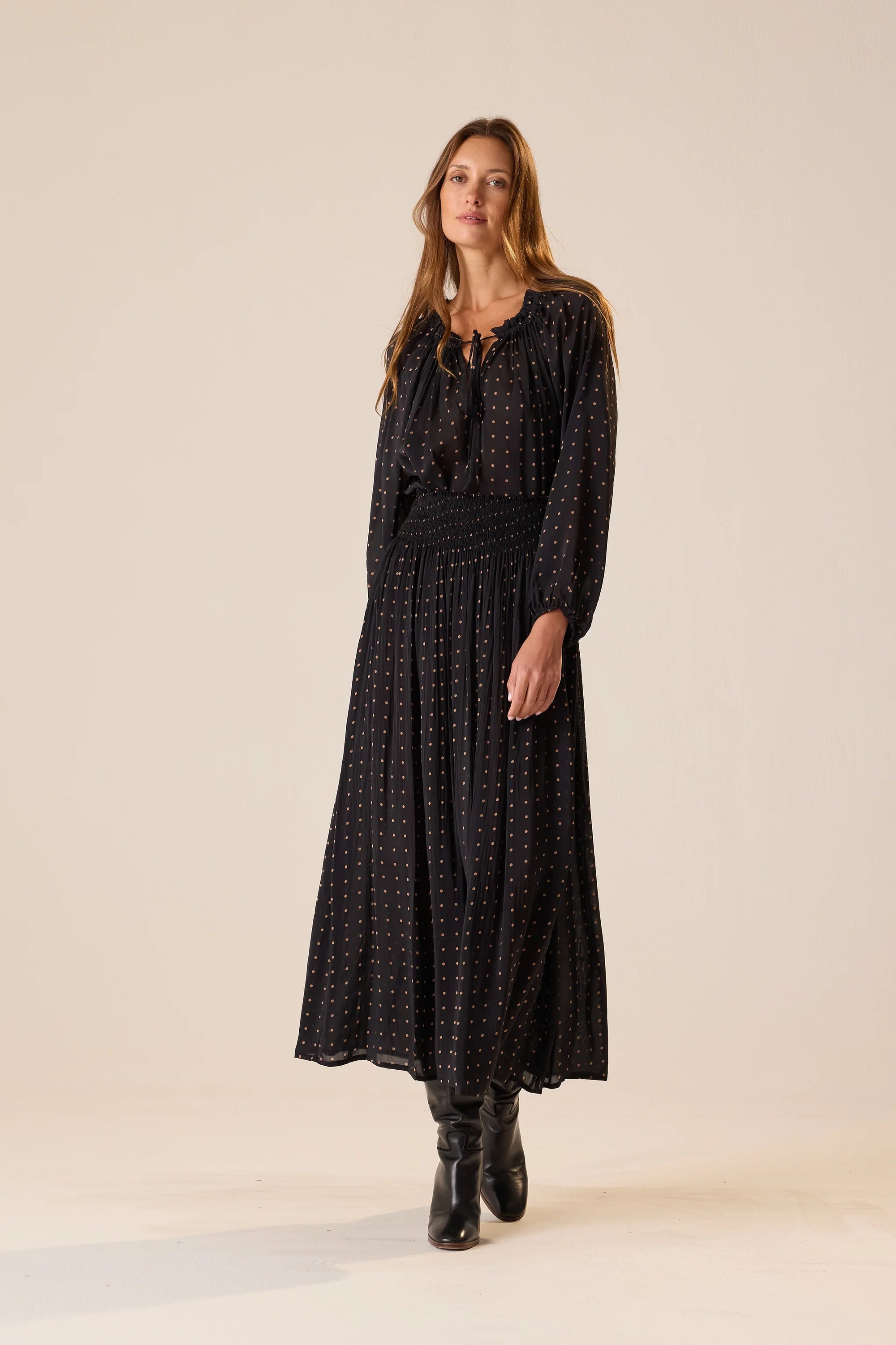 Bella Skirt in Polka Dot Black Tan by Natalie Martin, styled with black boots, shown on a simple backdrop.