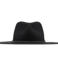 The Maxine Black Fedora by Ninakuru is a stylish wool hat with a wide-brimmed design in black and features a vegetable tanned leather band encircling the crown. Its smooth, felt-like texture and slightly indented top provide both elegance and sun protection, set against a plain white background.