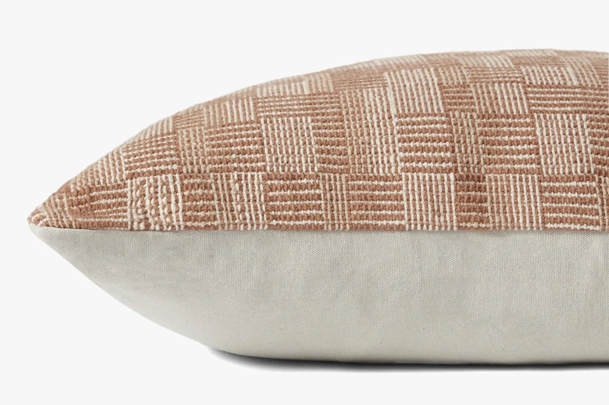 A close-up of the PAL0023 Dolly Clay Pillow by Loloi Rugs, featuring a rectangular shape, textured beige and tan checkered pattern on top, solid light fabric underneath, and the Loloi logo subtly displayed against a plain background.